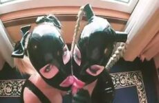 Zwei Frauen mit Latex-Masken blasen ihm einen